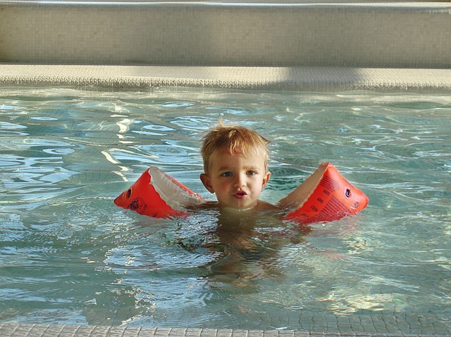 mall child with water wings in pool