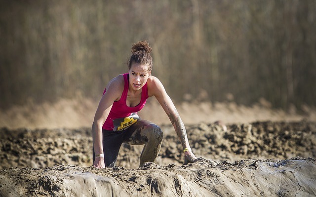 Femme pataugeant dans la boue pendant la course